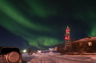 View of illuminated building against sky at night during winter