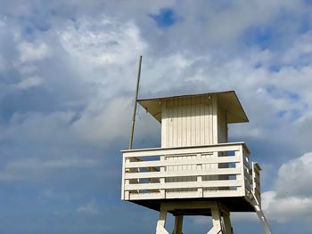 Lifeguard tower on a deserted beach on a clear day with white clouds 