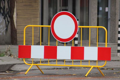 Close-up of road sign against brick wall