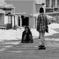 Friends skateboarding on road during winter