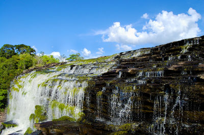 Low angle view of waterfall against sky