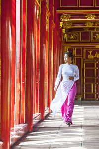 Full length of woman standing against building