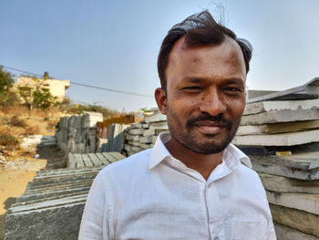 Portrait of smiling man standing against sky