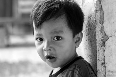 Close-up portrait of boy against wall