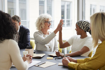 Businesswomen high fiving in office