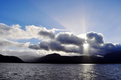 Scenic view of sea and mountains against sky