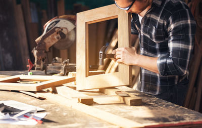 Carpenter working on woodworking machines in carpentry shop. a man works in a carpentry shop. person
