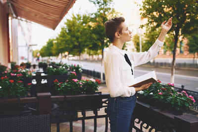 Woman standing by potted plants