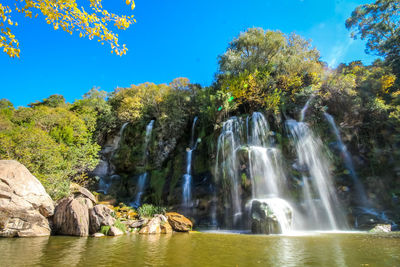 Scenic view of waterfall against sky