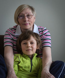 Portrait of grandmother and grandson sitting at home