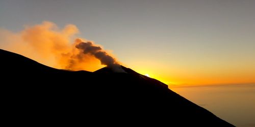 Scenic view of silhouette mountains against sky during sunset