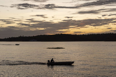 Beautiful amazon sunset with small boat over the waters of negro river