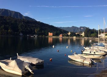 Boats moored in lake against sky