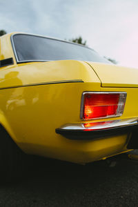 Close-up of yellow car on street