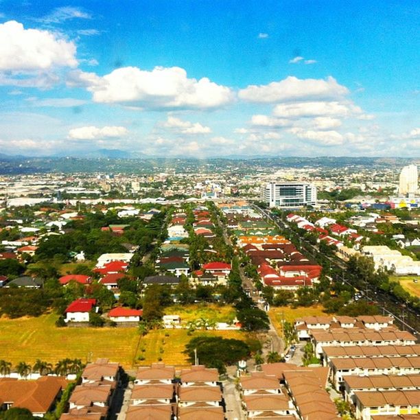 building exterior, architecture, built structure, cityscape, crowded, city, residential district, high angle view, sky, residential structure, residential building, roof, house, townscape, town, cloud - sky, tree, cloud, human settlement, blue