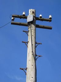 Telegraph pole against blue sky