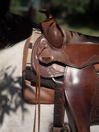 Close up of a western saddle on a white andalusian horse.