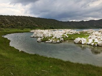 Scenic view of lake against cloudy sky