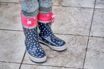 Low section of woman standing on footpath