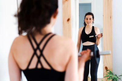 Side view of young woman exercising in gym