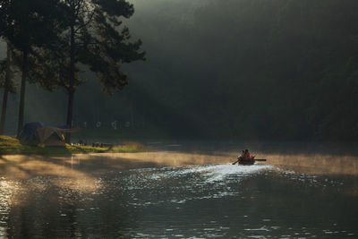 People on river against trees