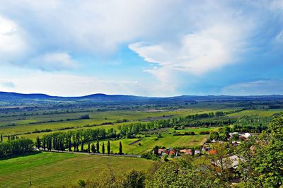 Scenic view of field against cloudy sky