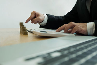 Midsection of man using mobile phone on table