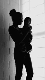 Silhouette couple standing against wall