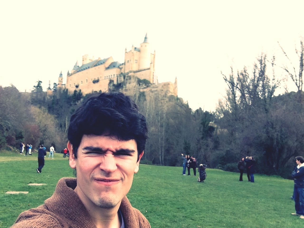 lifestyles, leisure activity, portrait, young adult, looking at camera, person, grass, young men, architecture, tree, clear sky, smiling, built structure, building exterior, front view, happiness, park - man made space, field