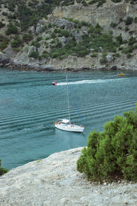 Sailboat sailing on sea by mountain