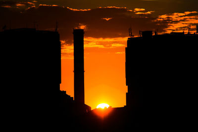 Silhouette buildings against sky during sunset