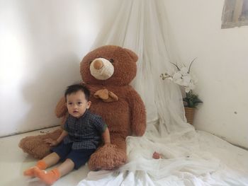 Cute baby girl sitting on bed at home