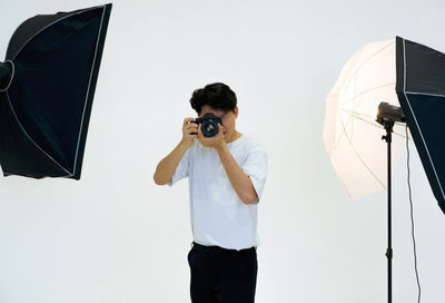 Reflection of man photographing on camera