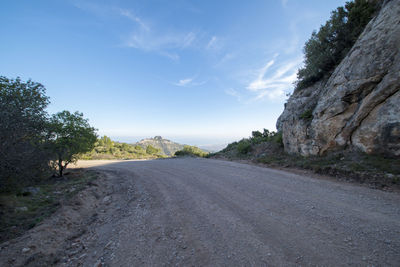 Road amidst trees against sky