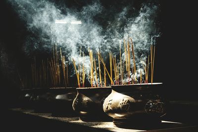 Close-up of incenses burning outside temple