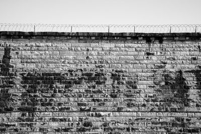 Low angle view of brick wall against clear sky