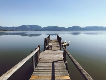 Pier over lake against clear sky