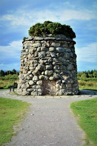 Stone wall on field against sky