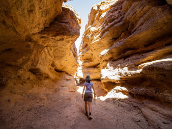 Rear view of man walking on rock