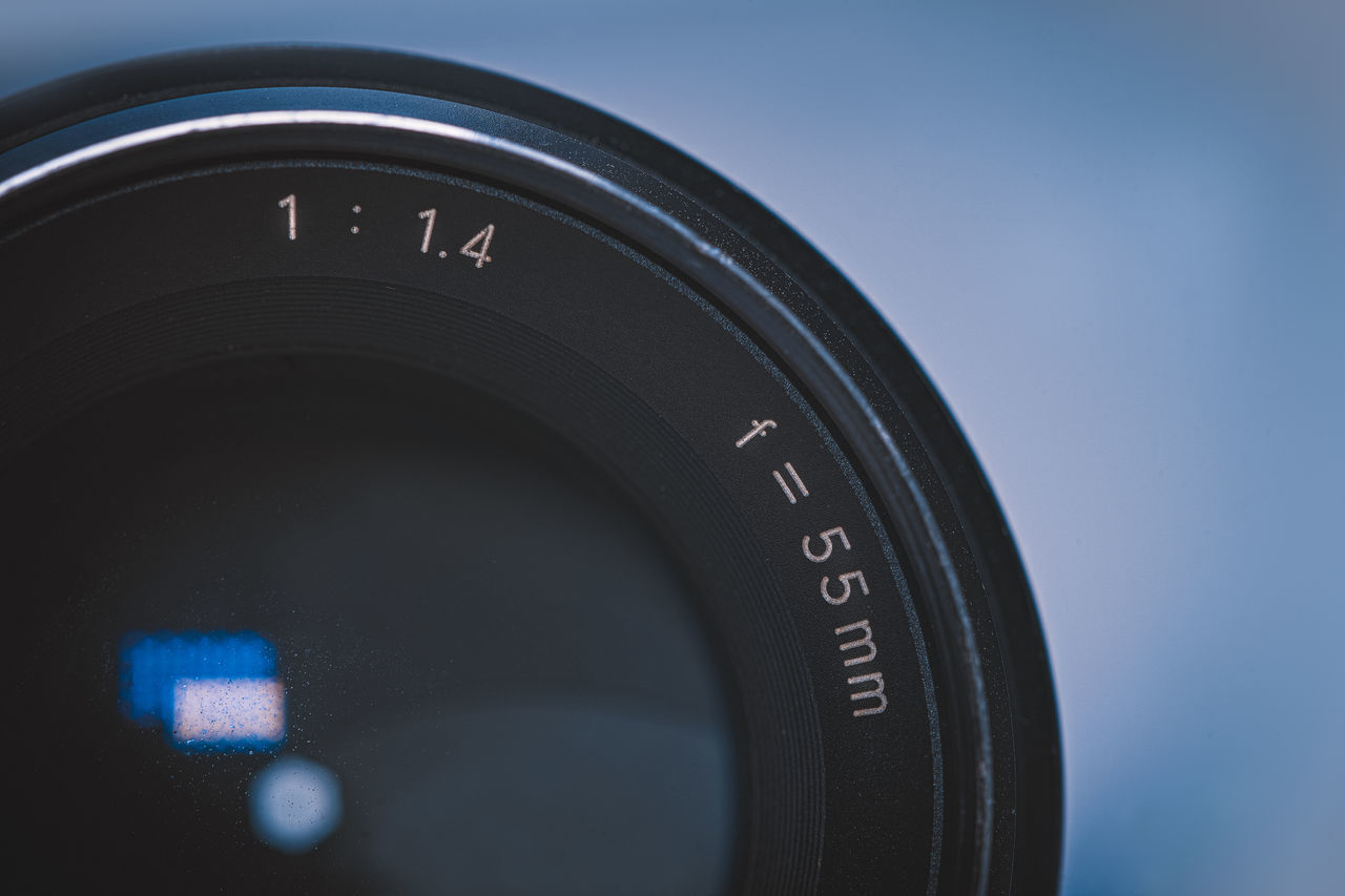CLOSE-UP OF CAMERA LENS ON MIRROR