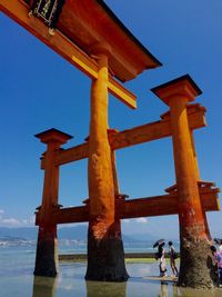 Low angle view of cross on beach against clear sky