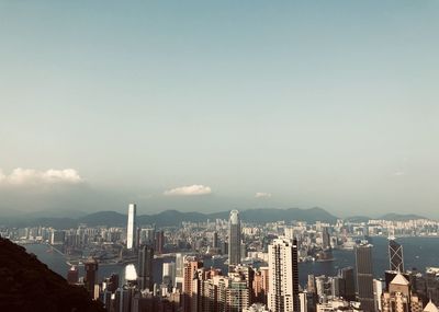 Aerial view of city buildings against cloudy sky