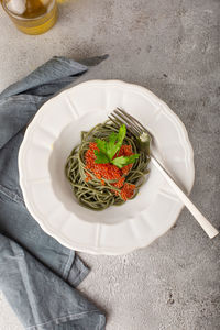 Spirulina noodles with red caviar on a white plate top view