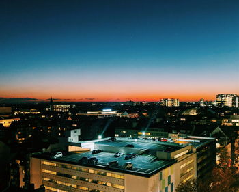 High angle view of illuminated buildings against clear sky at night