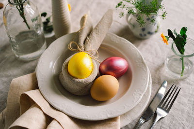 Happy easter. stylish easter eggs on a napkin with spring flowers on white wooden background