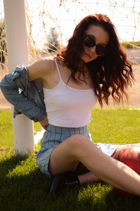 Young woman sitting on grassy field