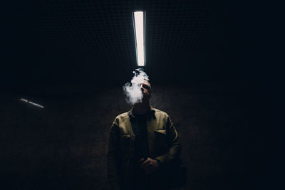 Mid adult man standing against black background