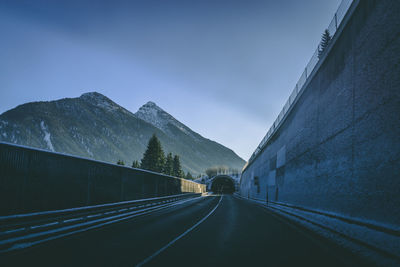 Road leading towards mountains against sky