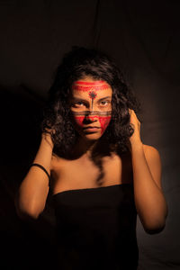 Portrait of beautiful woman against black background