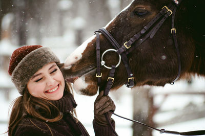 Close-up of beautiful woman with horse on field during snowfall8